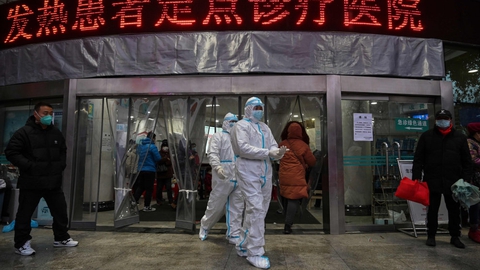 Smittede med coronavirus får blandt andet feber og begynder at hoste. På billedet ses personale i beskyttelsesdragter, der går ud af et hospital i Wuhan.