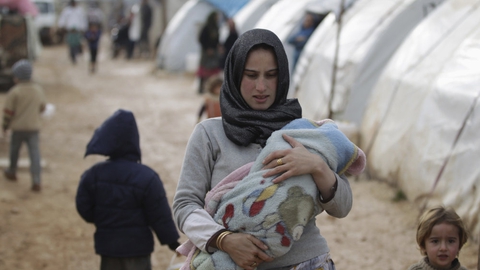 En intern fordreven  kvinde med sin baby i flygtningelejren Al-Karameh nær den syrisk-tyrkiuske grænse i Idlib. Rusland siger fredag, at rapporter om, at hundredtusinder af flygtninge er på vej væk fra Idlib i Syrien med retning mod Tyrkiet, er usande. (Arkivfoto)