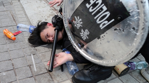 Politiet i Hongkong anholder en ung demonstrant i Hongkong, efter at et kinesisk flag blev flyttet under protester mod krænkelser af uighurernes rettigheder.  (Arkivtoto)