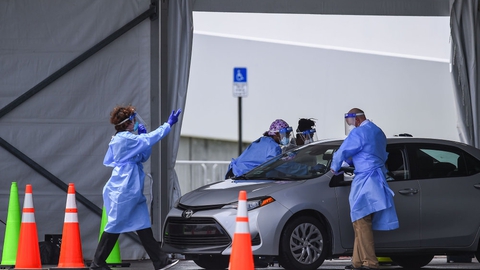 Florida er en af de mindst 18 delstater, som har oplevet mere end en fordobling i antallet af smittetilfælde i juli. Her ses medicinsk personale i Florida teste en borger for coronavirus.