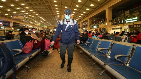 En medarbejder desinficerer togstationen i Wuhan. Byen lukker for offentlig transport torsdag formiddag. Udgående tog og fly fra byen bliver der ligeledes lukket for.