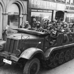 (ARKIV) Tyske motorvogne kører gennem Aabenraas gader hilst af hjemmetyskere. (Foto: Ritzau Scanpix)