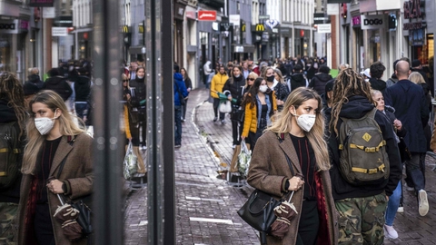 Mange af de handlende på et strøg i Amsterdam bærer mundbind. Nu skærper Hollands regering restriktionerne i et forsøg på at få bugt med coronasmitten.