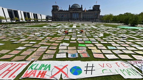Skilte på græsset foran Reichstag-bygningen under en "Fridays for Future"-klimademonstration den 24. april 2020 i Berlin. (Foto: John Macdougall/AFP/Ritzau Scanpix)