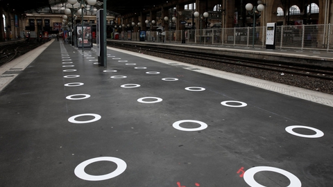 Cirkler er her blevet tegnet på jorden på en togstation i den franske hovedstad, Paris. Det skal få folk til at holde afstand til hinanden.
