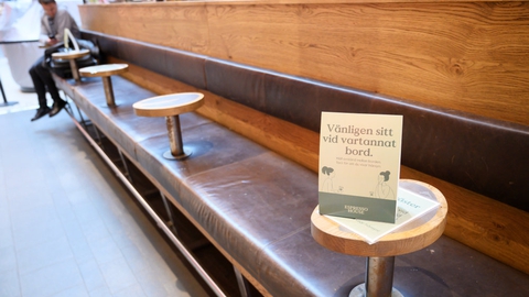Et skilt opfordrer kunder i butikscenteret Gallerian i Stockholm til at sidde ved hvert andet bord under coronakrisen.
