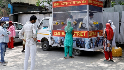 Folk venter her lørdag på at blive testet ved et mobilt testcenter i New Delhi i Indien.