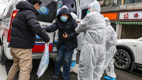 En patient bliver hjulpet ud af en ambulance af lægefolk med beskyttelsesmasker og dragter, der skal hindre smittte af den dødelige virus. Wuhan i Kinas Hubei-provins er epicenteret for coronovirusset. (Foto: AFP/Ritzau Scanpix)