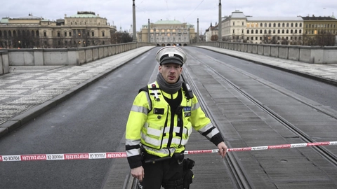 Betjent står vagt ved en bro, som fører til Jan Palach-pladsen i Prag.