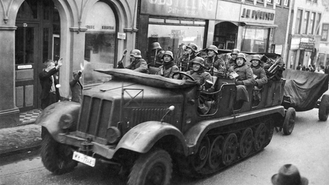 (ARKIV) Tyske motorvogne kører gennem Aabenraas gader hilst af hjemmetyskere. (Foto: Ritzau Scanpix)