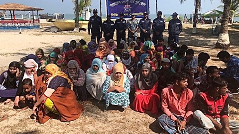 En del af de overlevende fra forlis i Den Bengalske Bugt ses her på en strand i Bangladesh, efter at de var blevet reddet i land af kystvagten.