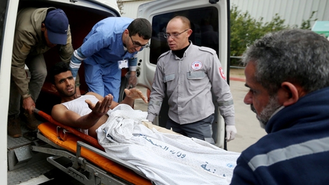 En palæstinenser, der er såret under israelsk beskydning søndag ved grænsen mellem Gaza og Israel, gestikulerer, mens han bringes til et hospital i den palæstinensiske enklave.