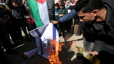 Palæstinensiske demonstranter brænder det israelske flag af under en demonstration i den sydlige del af Gazastriben fredag.