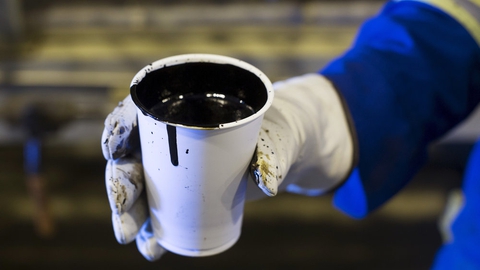 En arbejder holder en stor kop med olie. Ifølge en rapport bør Norge stoppe med at lede efter fossilt brændsel, lade være med at udvide infrastrukturen i industrien og forbyde de mest forurenende og miljøskadelige former for olie- og gasudvinding.
