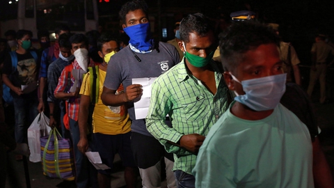 Migrantarbejdere, der har været strandet i den sydlige delstat Kerala på grund af Indiens hastige nedlukning, venter fredag på en togstation for at få lov at komme med på et tog til deres egen delstat Odisha i det østlige Indien.