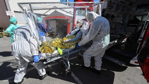 Ambulancemandskab bærer en patient på en indpakket båre fra ambulancen og ind på universitetshospitalet i byen Montpellier i det sydlige Frankrig.