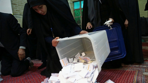 Valgtilforordnede tømmer stemmeboksene på et valgsted i Teheran. Der er blevet talt stemmer lørdag, og de peger på stor fremgang til høgene og de religiøst konservative i iransk politik.