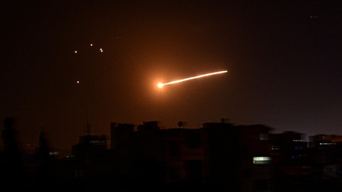 Her ses et lysglimt i himlen over Damaskus på et billede frigivet af det statslige syriske nyhedsbureau Sana.