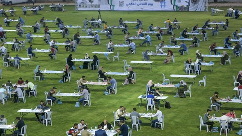Med behørig afstand mellem sig indtog palæstinensere i Gaza fredag aften iftar-måltidet, der afslutter den daglige faste under ramadanen. Hamas-bevægelsen, der kontrollerer Gaza, havde opstillet hundredvis af borde på et fodboldstadion i Gaza City.