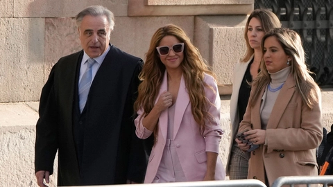 Shakira ankommer klædt i lyserødt til retsmøde i Spanien og smiler på vej ind.