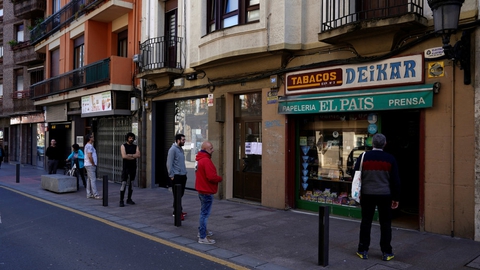 Folk i det nordlige Spanien holder afstand til hinanden, mens de venter i kø til en butik.
