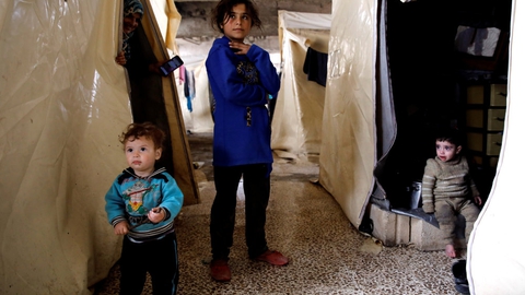 Børn af internt fordrevne syrere foran deres telt i en flygtningelejr i den syriske provins Idlib.