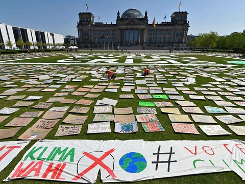 Skilte på græsset foran Reichstag-bygningen under en "Fridays for Future"-klimademonstration den 24. april 2020 i Berlin. (Foto: John Macdougall/AFP/Ritzau Scanpix)