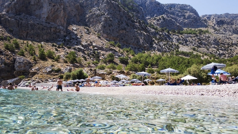 Strand på den græske ø Karpathos, hvortil det fortsat er muligt at rejse. (Arkivfoto)